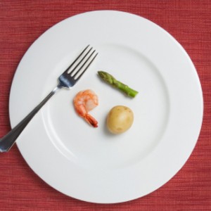 tiny meal consisting of one shrimp, a tiny potato, and a single short asparagus stalk